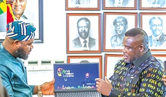 Samuel Nartey George (right),  Minister of Communication, Digital Technology and Innovations; and Mohammed Adams Sukparu, Deputy Minister of Communication, Digital Technology and Innovations, displaying one of the laptops