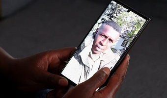 Felista Njoki, wife of Samuel Mwaura Wainaina who was recruited to fight in the Russia–Ukraine war, holds a phone displaying his photograph he sent her while in military gear, during a Reuters interview at their family home in Limuru, Kiambu County, Kenya, February 23, 2026. REUTERS/Monicah Mwangi