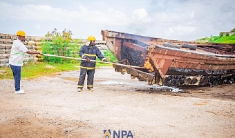 Godwin Edudzi Tamekloe (left), Chief Executive Officer of NPA, and a fire expert setting fire to the boats