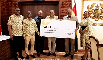  President John Dramani Mahama (2nd from right) receiving the dummy cheque from Farihan Alhassan (4th from right), MD, GCB Bank PLC, while other management staff look on
