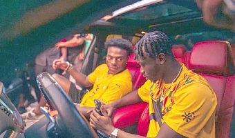 American IShowSpeed (left) being driven by Henry Appiah in a Chrysler Hellcat during the Supercar Spectacle