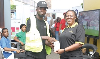 Gloria Adutwumwaa-Frimpong (right), Senior Manager, Data Devices and Home, MTN, presenting a Samsung Galaxy phone to Emmanuel Annang, the winner of the raffle game at the Daily Graphic-GREDA Home Fair held in Accra. Pictures: BENEDICT OBUOBI