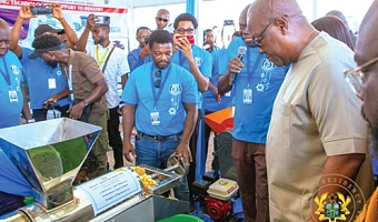 President John Dramani Mahama observing how a fruit juice extractor works during a tour of the exhibition