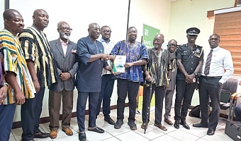 Dr Godwin Kafui Ayetor (in smock), Chairman of the Toyota Voxy Vehicles Investigative committee,  presenting a copy of the report to Abraham Amaliba, Director-General of the NRSA