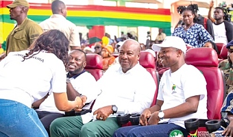 President John Dramani Mahama (2nd from right) and George Opare Addo (2nd from left), Minister of Youth Development and Empowerment   interacting with a beneficiary during the event