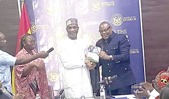 Emmanuel Habuka Bombande (right), Chairman of the committee, presenting the report to Muntaka Mohammed-Mubarak, the Minister for the Interior