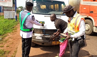Officers inspecting and advising a driver to observe road safety protocols