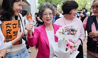 Choi Mal-ja, centre, celebrates with her supporters after the ruling. Photograph: Yonhap/AFP/Getty
