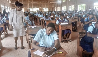 Dr Rosemond Wilson (standing), Head of the National Office of WAEC, examining the script of a candidate at the Armed Forces Senior High Technical School, Burma Camp
