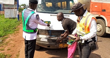 Officers inspecting and advising a driver to observe road safety protocols