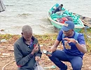 Daily Graphic's Timothy Ngnenbe interacting with Noah Aggrey as he mends his net at the shores of Azizape Island.