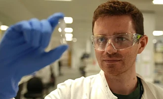 Researcher Alex Sampson holds the experimental Ebola vaccine