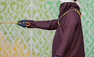 A robed and hooded official prepares to flog a Sharia law violator in Banda Aceh, Indonesia on Thursday. Photograph: Muhammad Iqbal/Zuma Press Wire/Shutterstock