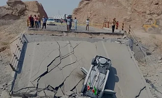 An overturned car sits on a section of a destroyed bridge after a strike in Hormozgan province, southern Iran, Saturday, July 18, 2026. (Mahdi Negahban/Mehr News Agency via AP)
