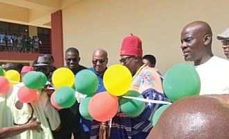 President John Mahama being supported by Pe Gideon Awolugu (2nd from right), Chief of Nakolo, and Nikyema Billa Alamzy (2nd from left), MP, Chiana-Paga Constituency, to cut the ribbon while Haruna Iddrisu (right), Minister of Education, looks on