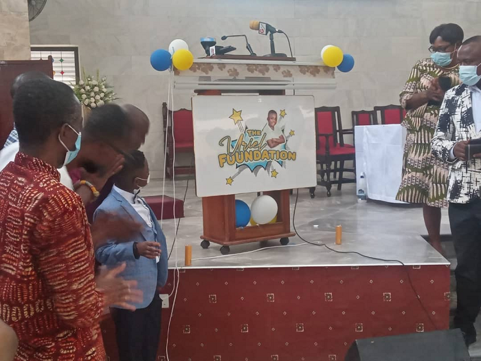Master Uriel Prince Boateng Aryeetey with some dignitaries at the launch of the Uriel Foundation admiring the logo for the Foundation 
